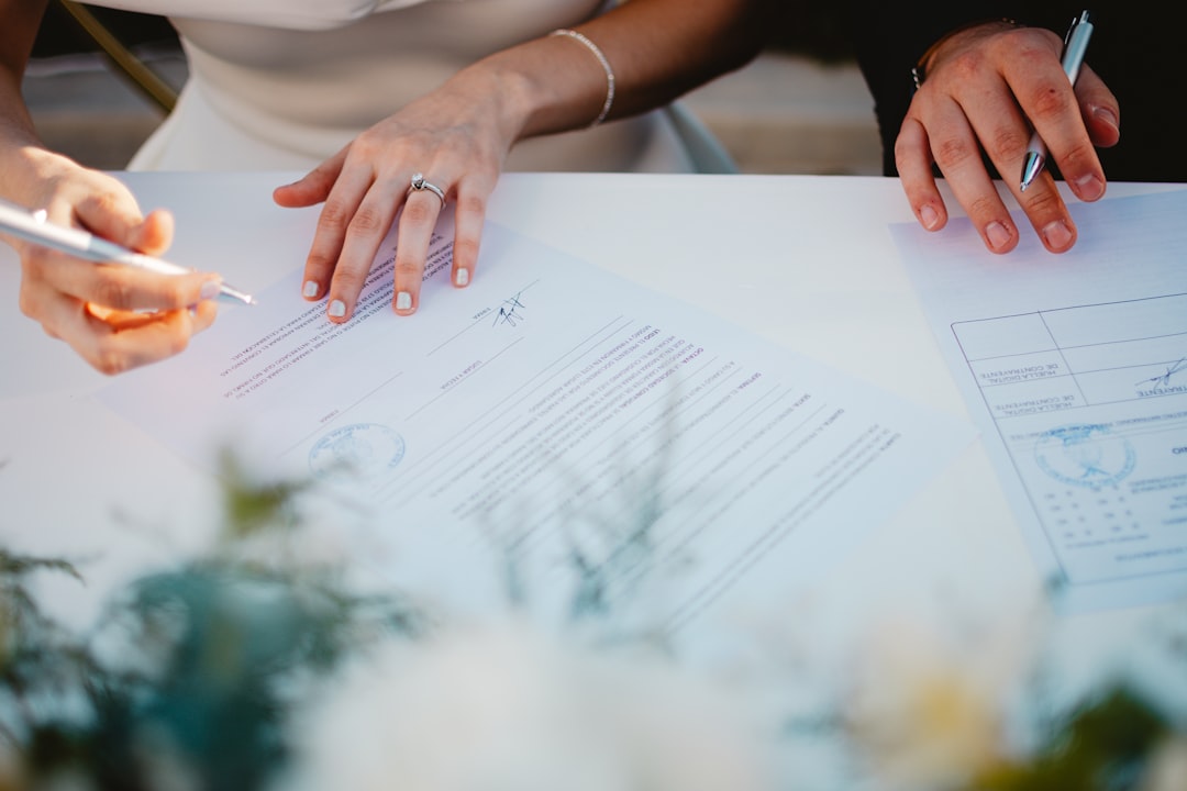couple-signing-marriage-documents-at-a-table-4rfrggc0hra